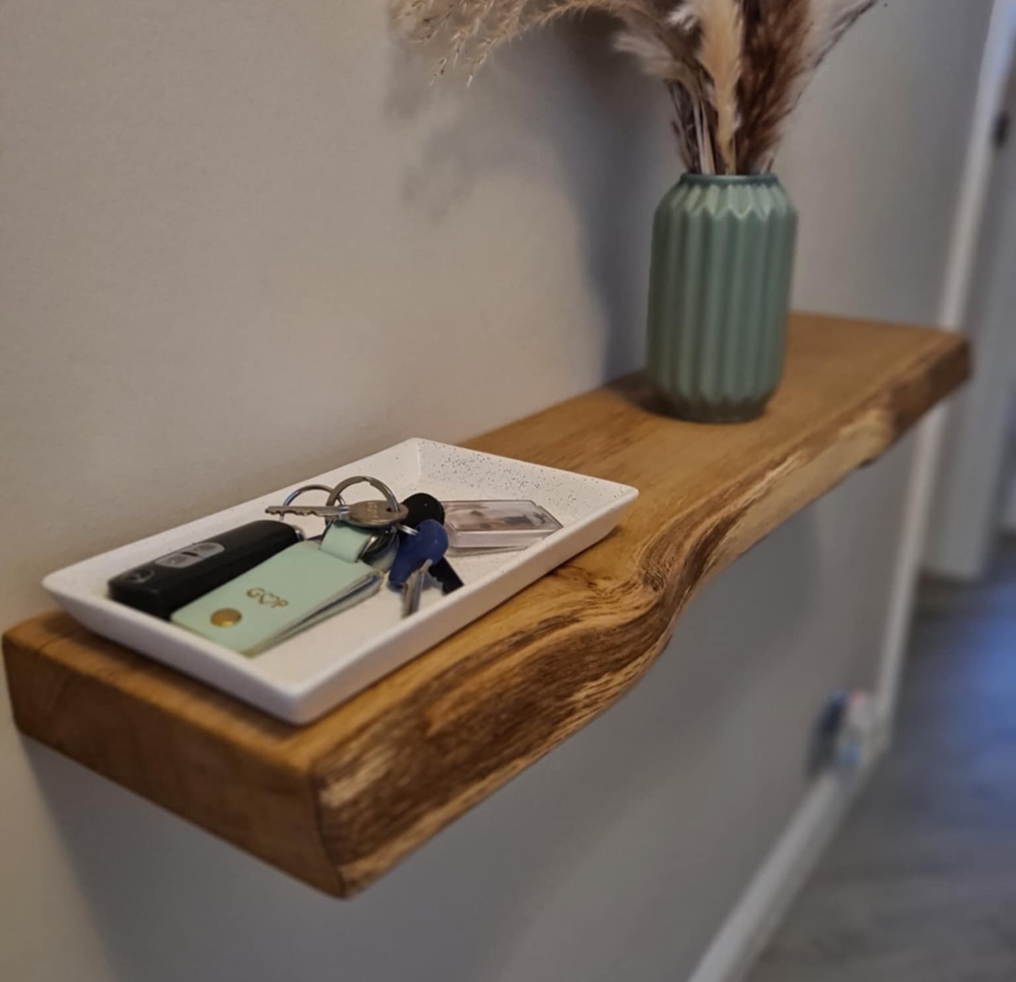Close-up of a bespoke Fuscina floating oak shelf with steel bracket