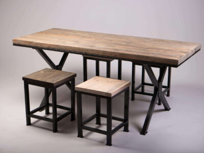 Industrial dining table with reclaimed wood top and black steel X-frame legs, with two matching wooden stools
